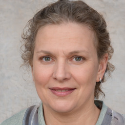 Joyful white adult female with medium  brown hair and blue eyes