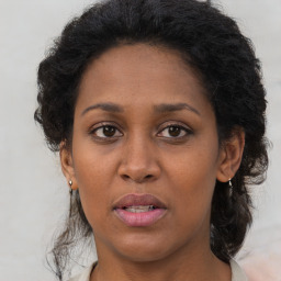 Joyful black adult female with long  brown hair and brown eyes