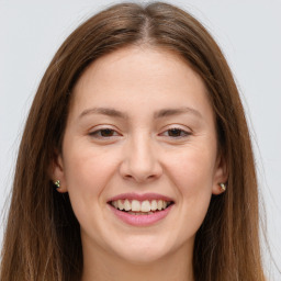 Joyful white young-adult female with long  brown hair and green eyes