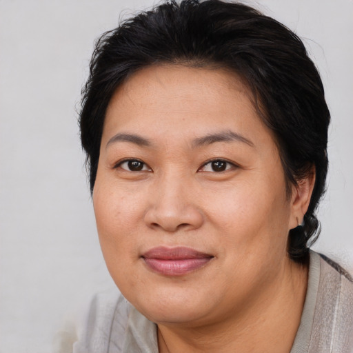 Joyful asian adult female with short  brown hair and brown eyes