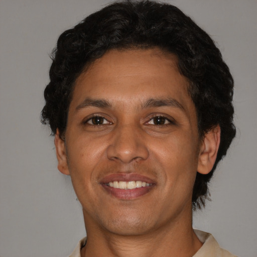 Joyful latino young-adult male with short  brown hair and brown eyes