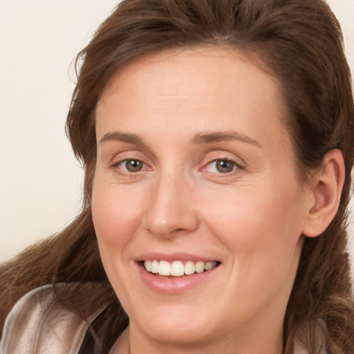 Joyful white adult female with long  brown hair and grey eyes