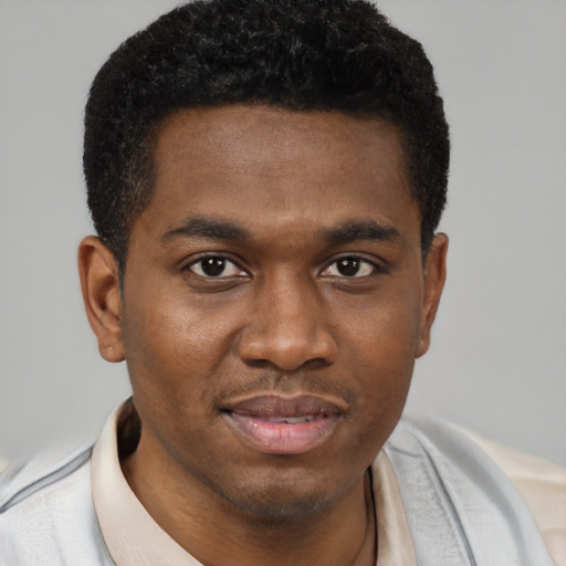 Joyful black young-adult male with short  brown hair and brown eyes