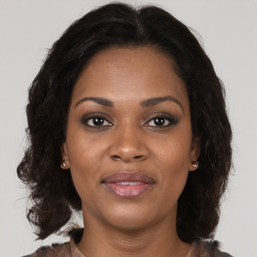 Joyful black young-adult female with medium  brown hair and brown eyes