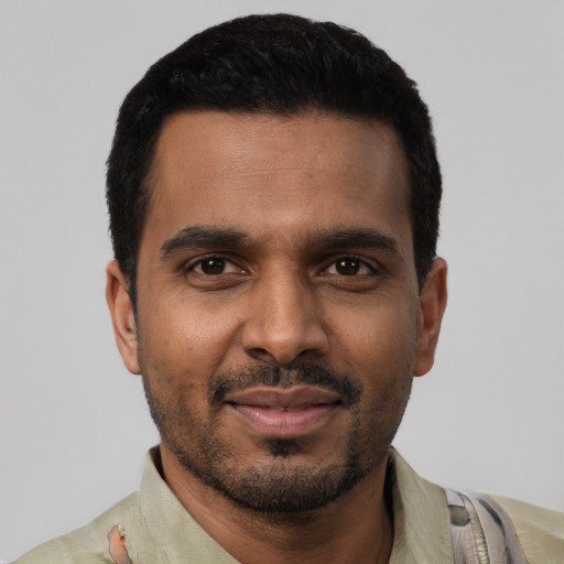 Joyful black young-adult male with short  black hair and brown eyes