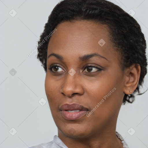 Joyful black young-adult female with short  black hair and brown eyes