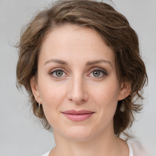 Joyful white young-adult female with medium  brown hair and green eyes