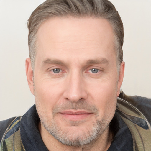 Joyful white adult male with short  brown hair and grey eyes