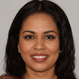 Joyful latino young-adult female with long  brown hair and brown eyes