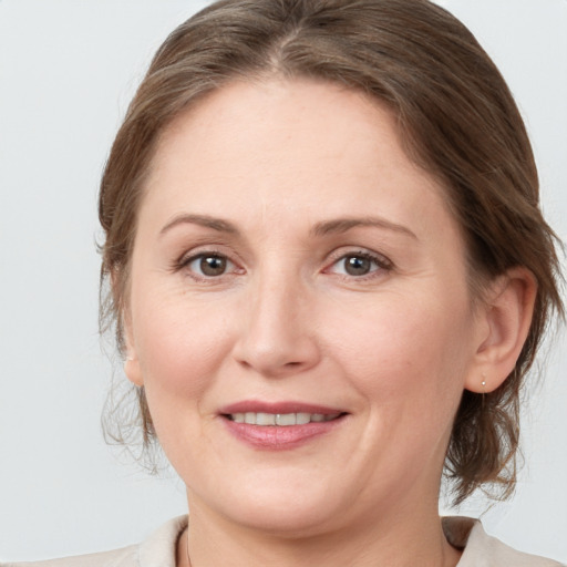 Joyful white adult female with medium  brown hair and grey eyes