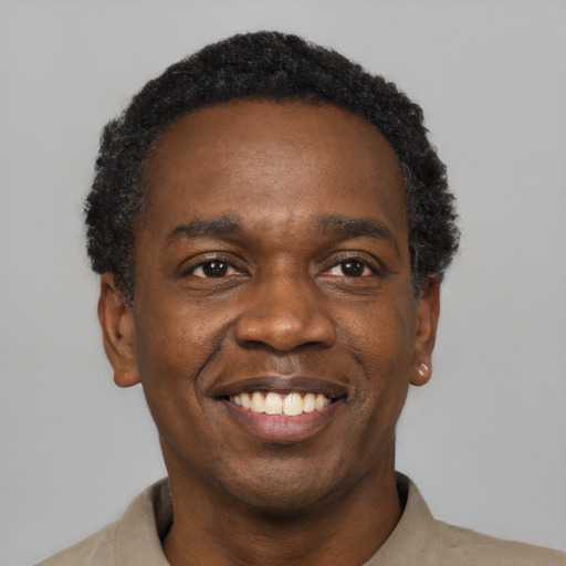 Joyful black adult male with short  black hair and brown eyes