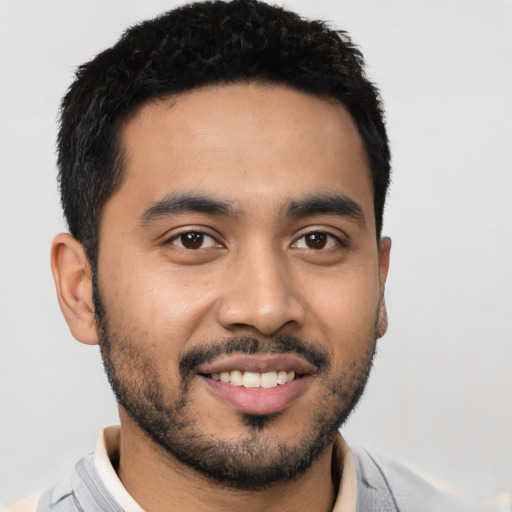 Joyful latino young-adult male with short  black hair and brown eyes