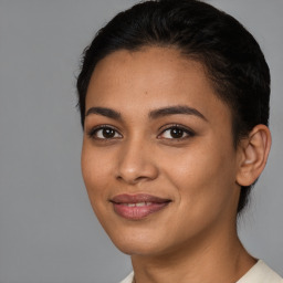 Joyful latino young-adult female with short  black hair and brown eyes