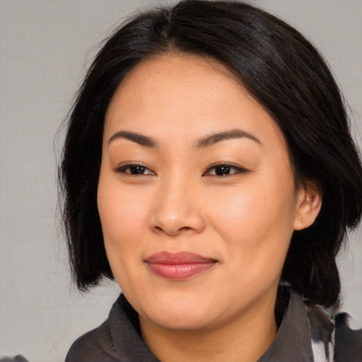 Joyful asian young-adult female with medium  brown hair and brown eyes