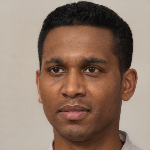 Joyful black young-adult male with short  black hair and brown eyes