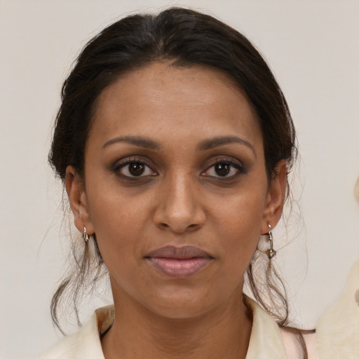 Joyful black adult female with medium  brown hair and brown eyes