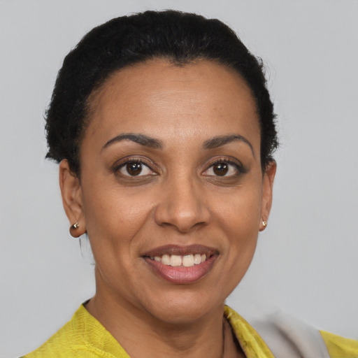 Joyful black young-adult female with short  brown hair and brown eyes