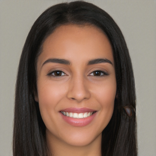 Joyful latino young-adult female with long  brown hair and brown eyes