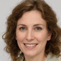 Joyful white adult female with medium  brown hair and green eyes