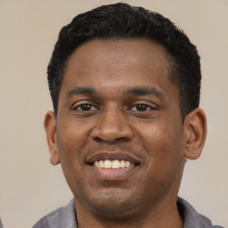 Joyful latino young-adult male with short  black hair and brown eyes