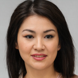 Joyful asian young-adult female with long  brown hair and brown eyes