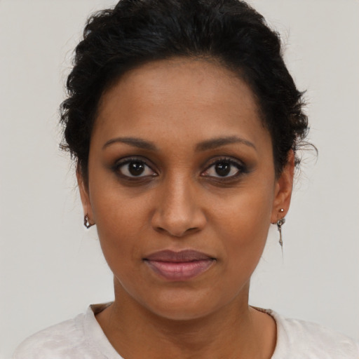 Joyful black young-adult female with short  brown hair and brown eyes