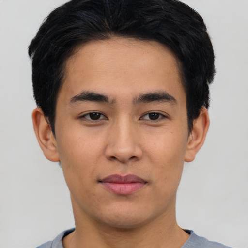 Joyful asian young-adult male with short  black hair and brown eyes