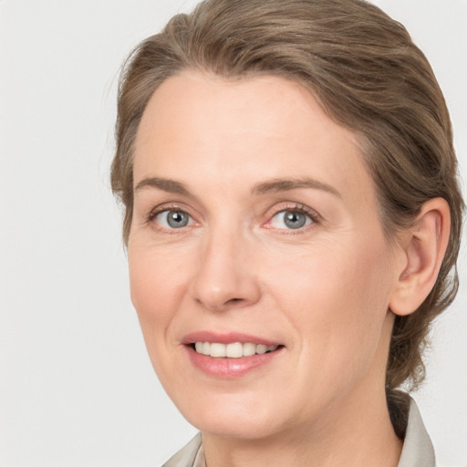 Joyful white adult female with medium  brown hair and grey eyes