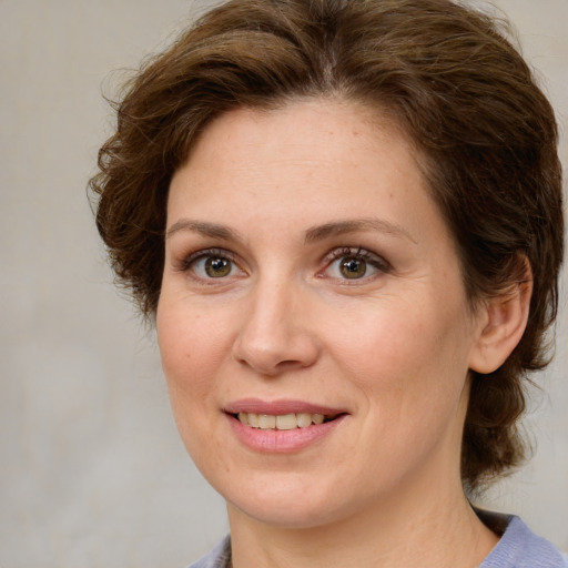 Joyful white adult female with medium  brown hair and green eyes