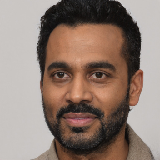 Joyful black young-adult male with short  black hair and brown eyes