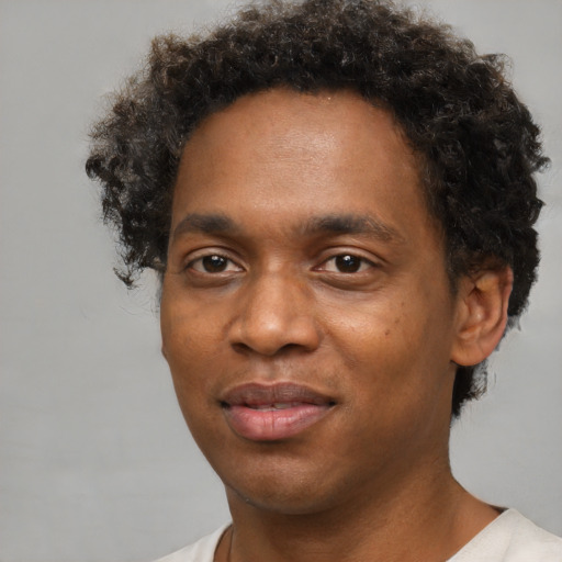 Joyful black young-adult male with short  brown hair and brown eyes