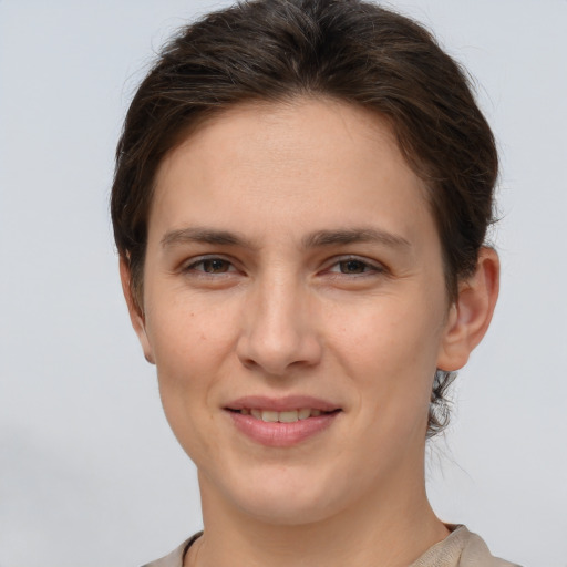 Joyful white young-adult female with short  brown hair and grey eyes