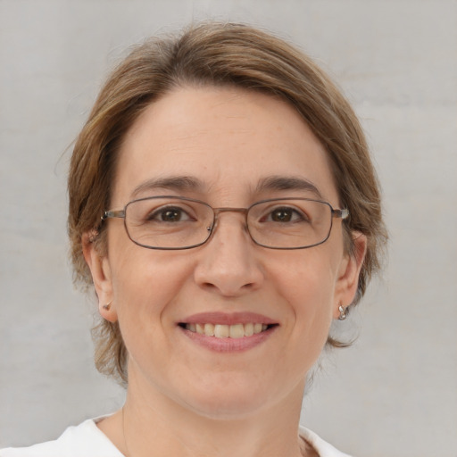 Joyful white adult female with medium  brown hair and green eyes