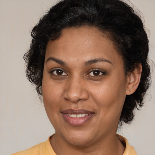 Joyful latino adult female with medium  brown hair and brown eyes
