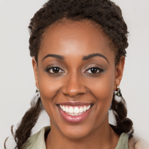 Joyful black young-adult female with medium  brown hair and brown eyes