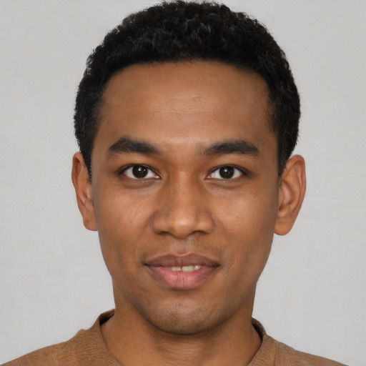 Joyful black young-adult male with short  black hair and brown eyes