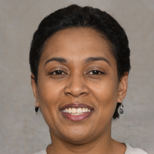 Joyful latino adult female with short  black hair and brown eyes
