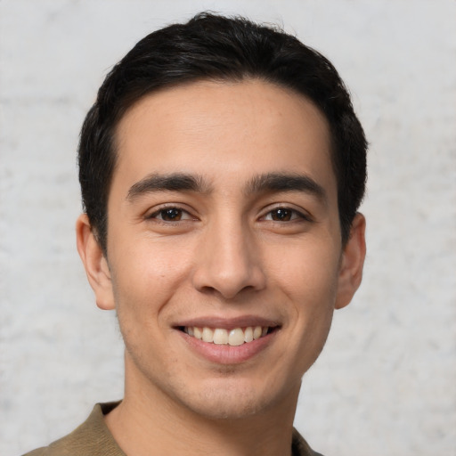 Joyful latino young-adult male with short  black hair and brown eyes