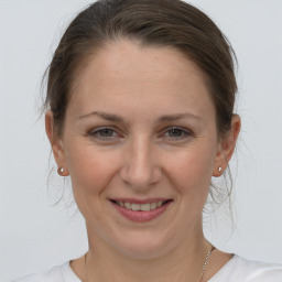 Joyful white adult female with medium  brown hair and grey eyes