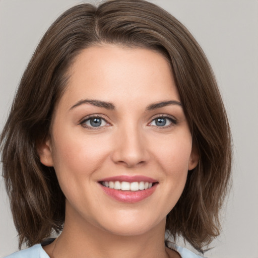 Joyful white young-adult female with medium  brown hair and green eyes