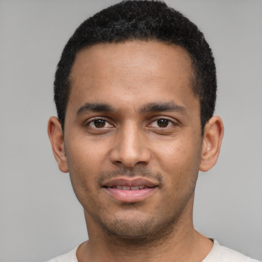 Joyful black young-adult male with short  black hair and brown eyes