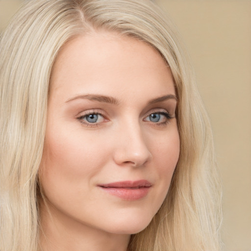 Joyful white young-adult female with long  blond hair and blue eyes