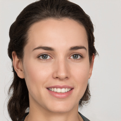 Joyful white young-adult female with medium  brown hair and grey eyes