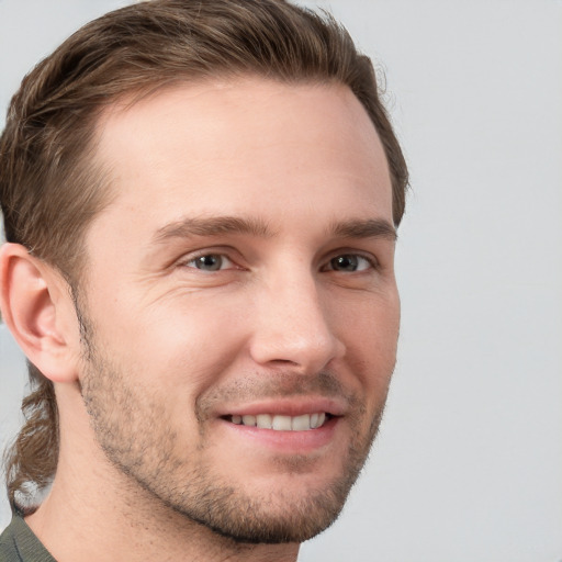 Joyful white young-adult male with short  brown hair and grey eyes