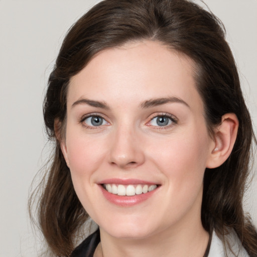 Joyful white young-adult female with medium  brown hair and grey eyes