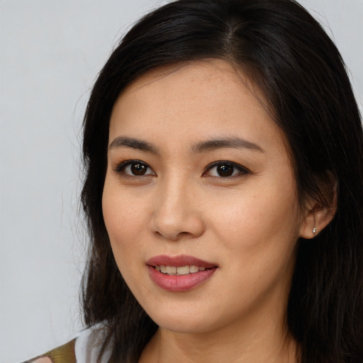 Joyful asian young-adult female with long  brown hair and brown eyes