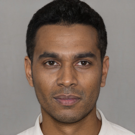 Joyful latino young-adult male with short  black hair and brown eyes