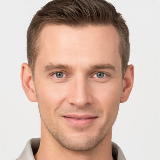 Joyful white young-adult male with short  brown hair and grey eyes