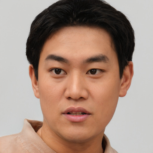 Joyful asian young-adult male with short  black hair and brown eyes