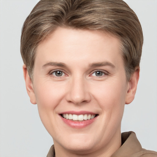 Joyful white young-adult female with short  brown hair and grey eyes